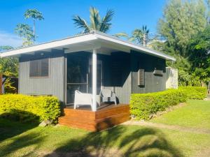 a small house with two white chairs on a deck at Studio self-contained and recently renovated in Avarua