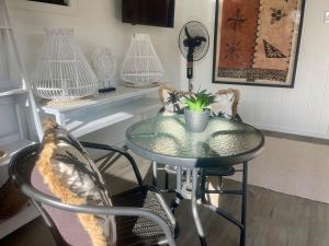 a table with a plant in a room with chairs at Studio self-contained and recently renovated in Avarua