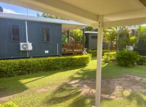 a yard with a blue house with a porch at Studio self-contained and recently renovated in Avarua +17 photos