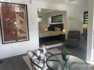 a living room with a table and a bedroom at Studio self-contained and recently renovated in Avarua