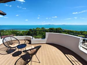 a balcony with chairs and tables and the ocean at Семеен хотел"Свети Георги" in Burgas