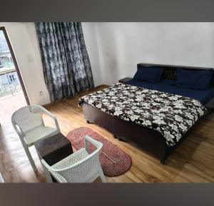 a bedroom with a bed and a chair and a rug at Swastik Hotel & Restaurant in Kharsālī