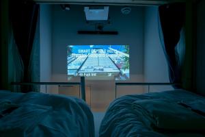 a projection screen in a room with two beds at Theatel Sapporo in Sapporo +4 photos
