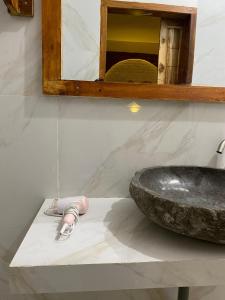 a bathroom with a stone sink and a slippers at Dira Bungalows in Tetebatu +148 photos