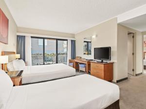 a hotel room with two beds and a flat screen tv at ibis Styles Port Macquarie in Port Macquarie