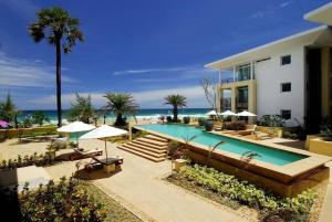 a house with a swimming pool next to the beach at Karon Beach Stunning 2 bed apt unit 700 in Karon Beach