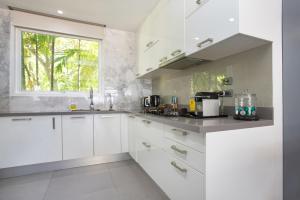 a white kitchen with white cabinets and a window at Karon Beach Stunning 2 bed apt unit 700 in Karon Beach