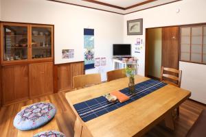 a dining room table with a vase on top of it at DON chan GuestHouse Nikko ,7 minutes walk from Imaichi Station in Nikko