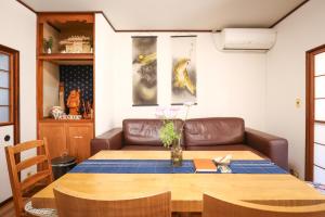 a dining room with a table and a couch at DON chan GuestHouse Nikko ,7 minutes walk from Imaichi Station in Nikko