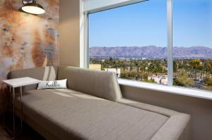 a couch in a room with a large window at Cambria Hotel Phoenix Chandler - Fashion Center in Chandler