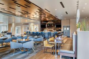 a restaurant with blue chairs and tables and a bar at Cambria Hotel Phoenix Chandler - Fashion Center in Chandler
