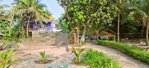 a house in the middle of a yard with trees at Nestle Sahayadri BeachFront Homestay Murudeshwar in Māvalli