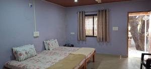 a bedroom with a bed and a window at Nestle Sahayadri BeachFront Homestay Murudeshwar in Māvalli