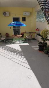 a patio with a table and a blue umbrella at Victoria's dream in Filiatra