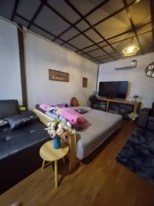 a bedroom with a bed and a couch and a table at Rim Tarn Phu View Chiang Mai in Ban Khanin Tai