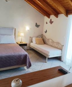 a bedroom with a bed and a couch and a table at Rousis Studios in Parga