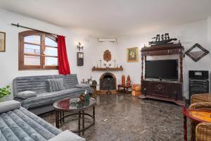 a living room with a couch and a television at Villa en Capistrano V. 4 a 9 plazas in Nerja