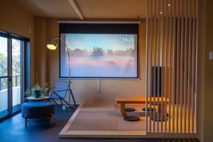 a living room with a large projection screen on the wall at Villa LUAR in Minamiawaji