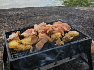 a grill with meat and other food on it at Sigiri Lake Paradise in Sigiriya