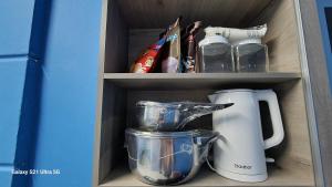 a cabinet with a blender and other kitchen items at homestay chendorini cherating in Kampong Chendar