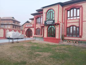 a large brick building with a tent in front of it at John's palace in Srinagar