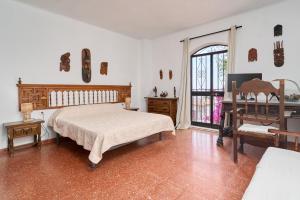 a bedroom with a bed and a table and a window at Villa en Capistrano V. 4 a 9 plazas in Nerja +25 photos