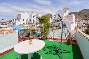 a balcony with chairs and a table on a roof at Villa en Capistrano V. 4 a 9 plazas in Nerja