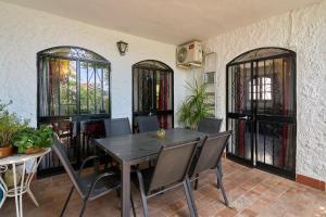 a dining room with a table and chairs and stained glass windows at Villa en Capistrano V. 4 a 9 plazas in Nerja