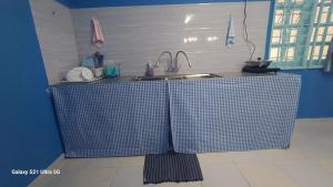 a kitchen with two counters with a sink and a counter at homestay chendorini cherating in Kampong Chendar +8 photos