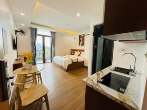 a hotel room with a bed and a kitchen with a sink at A90 HOTEl2 in Nhật Tựu