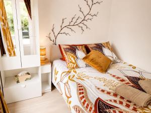 a bedroom with a bed with a branch on the wall at Cosy Green in Waulsort