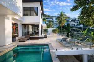 an exterior view of a house with a swimming pool at Skyline Seaview Villa-5 Bedroom, 4 Bathrooms with Private Seaview Pool in Ban Thong Phlu