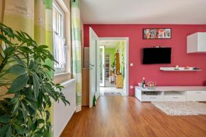 a living room with red walls and a potted plant at Ferienwohnung Kleinramspau in Regenstauf
