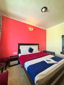 a bedroom with a red wall and a bed at IMPERIAL COTTAGE, HILL BUNK OOTY in Ooty