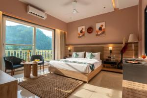 a bedroom with a bed and a large window at Moustache Select Rishikesh Mohanchatti in Mohan Chatti