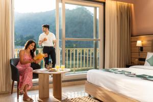 a man and a woman sitting in a chair in a hotel room at Moustache Select Rishikesh Mohanchatti in Mohan Chatti