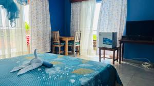 a bedroom with a bed with a toy shark on it at Nosy Bay View in Nosy Be