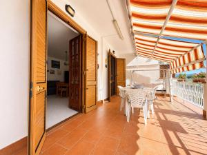 a room with a table and chairs on a balcony at Oasi Palma - Mondello in Palermo
