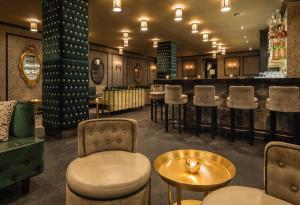 a bar with stools and a table and chairs at Dream Midtown, by Hyatt in New York