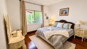 a bedroom with a bed and a window at Sals Cottage in Busselton