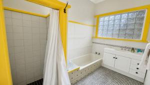 a bathroom with a tub and a shower curtain at Sals Cottage in Busselton +26 photos