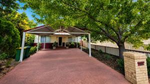 a driveway leading to a house with a canopy at Sals Cottage in Busselton