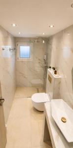 a white bathroom with a toilet and a sink at Limera View Monemvasia in Monemvasia +5 photos