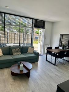 a living room with a green couch and a table at De Wulk 26 in Zandvoort