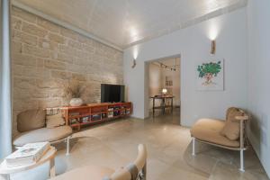 a living room with two chairs and a television at Albergo Egadi in Favignana