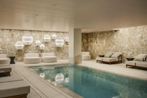una hall dell'hotel con piscina e sedie di Hyatt Centric Malta a San Giuliano