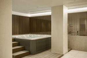 un bagno con vasca e alcune scale di Hyatt Centric Malta a San Giuliano Altre 119 foto