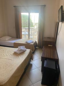 a room with two beds and a table and a window at GTH GLORİA GÜMBET HOTEL in Bodrum City +10 photos