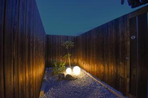 a room with a wooden fence with two lights at あかり by 4S STAY in Uchiko