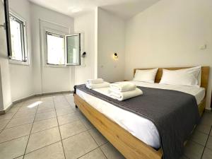 a bedroom with a large bed with towels on it at Enjoy Parga Appartments in Parga
